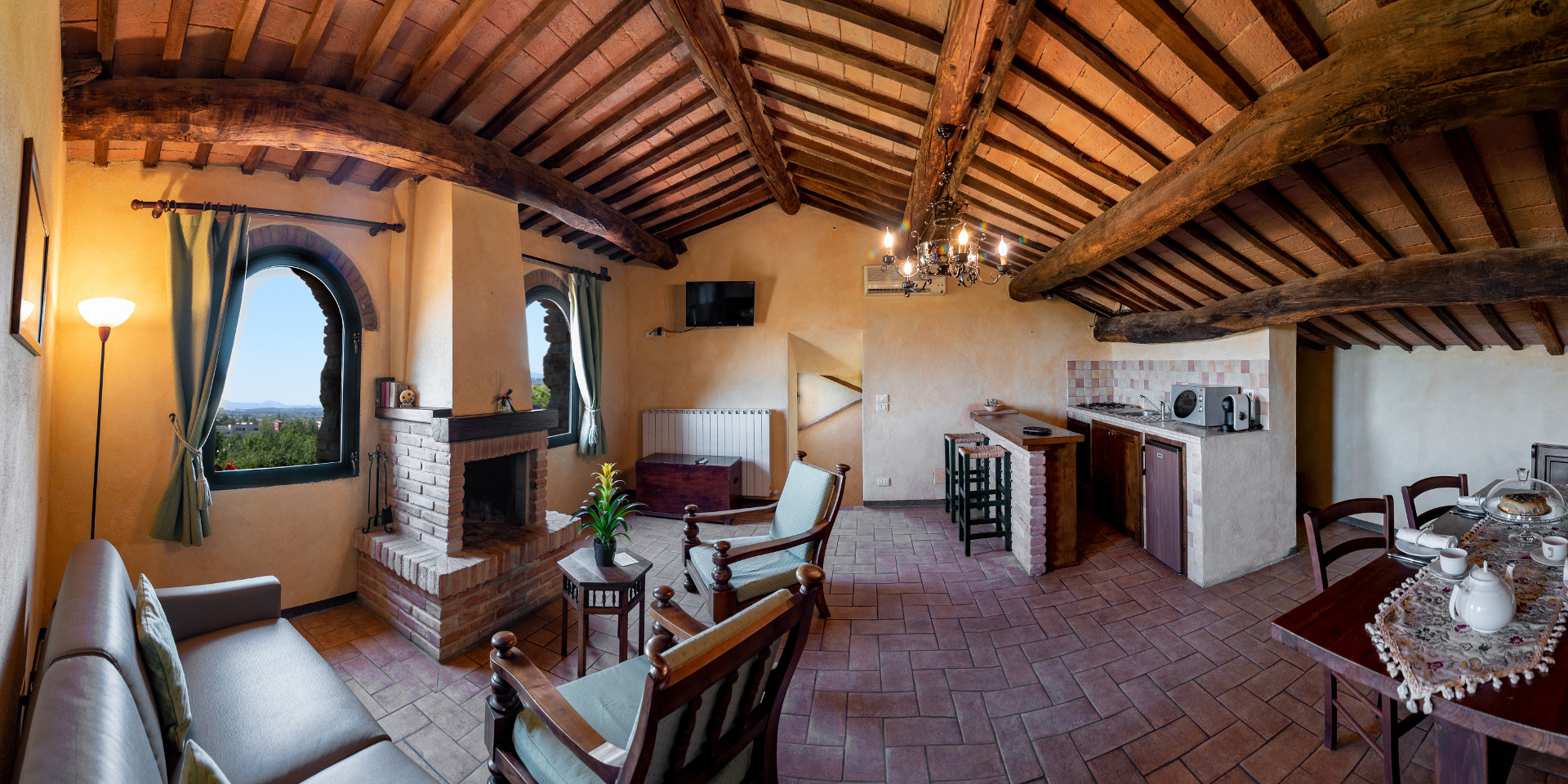 Foto panoramica di un soggiorno con cucina in uno degli appartamenti
					dell’Agriturismo Monastero San Silvestro