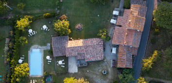 Photo from above zooming in on the park with pool of the ancient Monastero
									San Silvestro Farmhouse